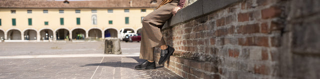 Primo piano di Finncomfort Neiva Scarpe Donna con Plantare Morbido schwarz/black indossato da donna appoggiata a un muretto in città.