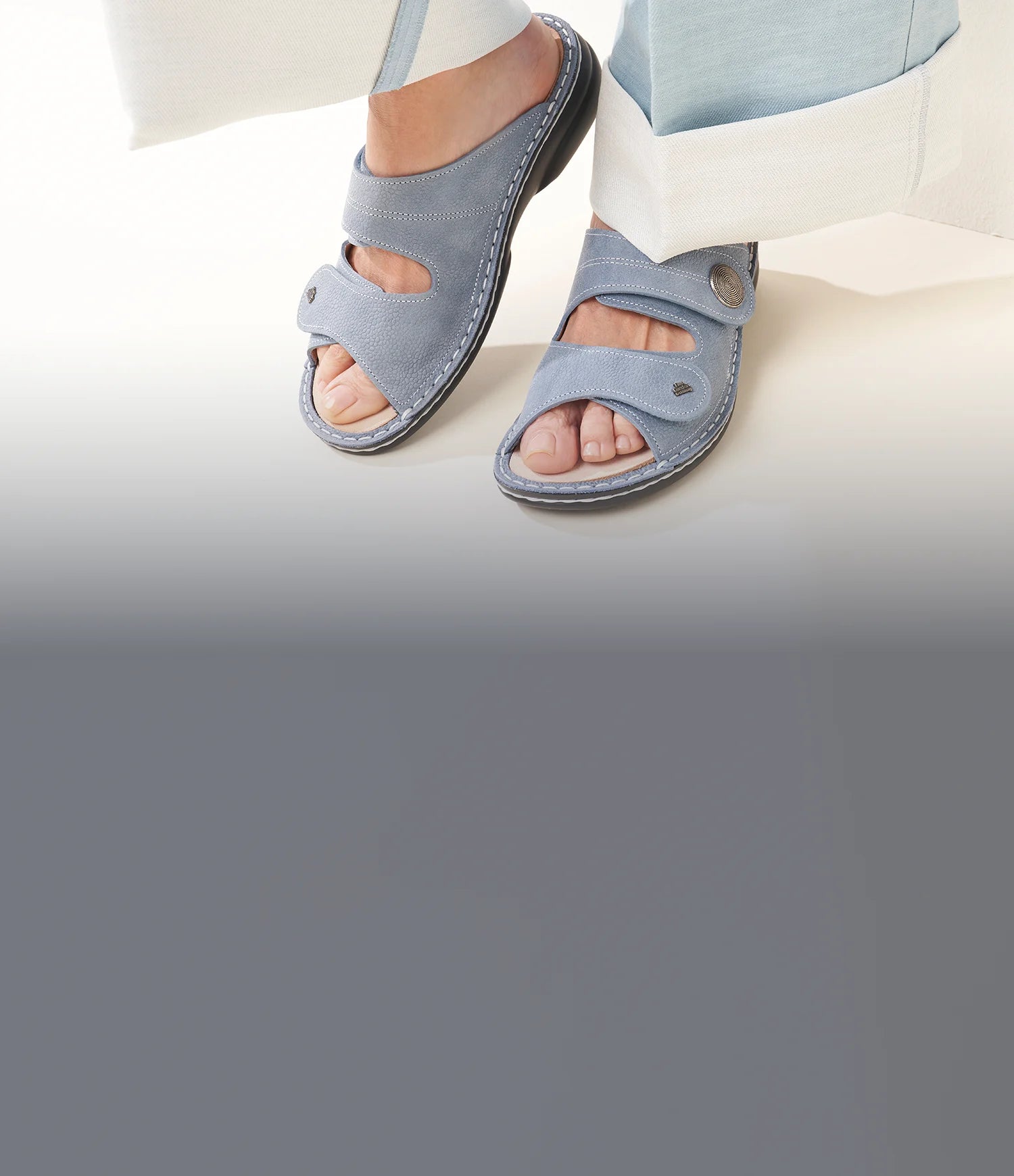 Primo piano di sansibar ciabatte donna color azzurro indossate da donna con pantaloni azzurri