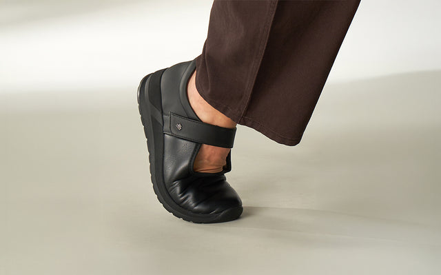 primo piano di scarpa ballerina sakae nera finncomfort indossata da donna mentre compie un passo e si vede flessibilità della scarpa