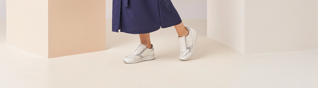 Primo piano scarpe FinnComfort indossate modello Mori FinnStretch bianco/argento, su sfondo chiaro