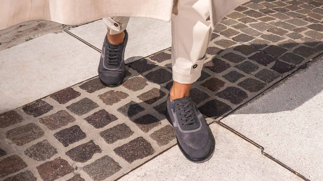 Primo piano di scarpe Finncomfort arinaga grigio strech indossate da donne che cammina per strada cittadina