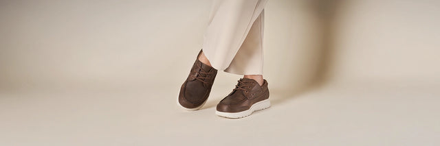 Primo piano di piedi di uomo che indossa Scarpe Uomo FinnComfort modello Sucre barrel, su sfondo chiaro