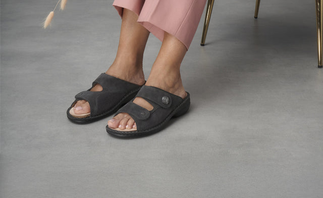 Primo piano con vista frontale e laterale di Ciabatte Finncomfort Sarezzo grigio Nubuk StretchRona indossate da donna con pantaloni rosa