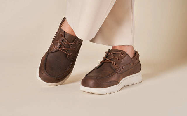 Primo piano di piedi di uomo che indossa Scarpe Uomo FinnComfort modello Sucre barrel, su sfondo chiaro